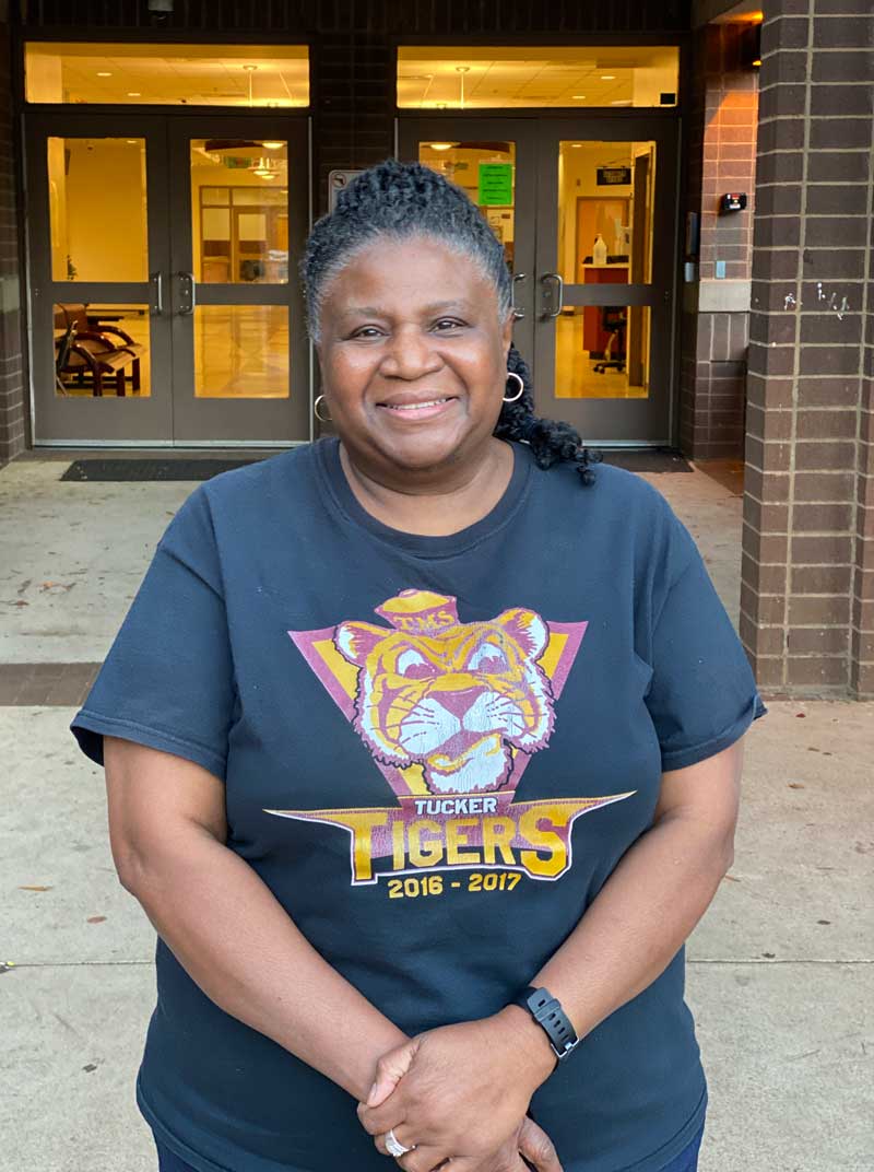 Smiling photo of Dr. Brenda Cunningham outside the entrance to Tucker Middle school.