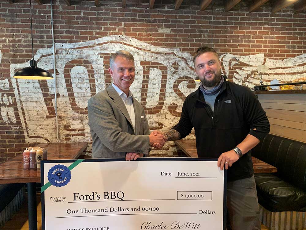Charles DeWitt presents Ford's Barbeque with Best of Tucker check. 