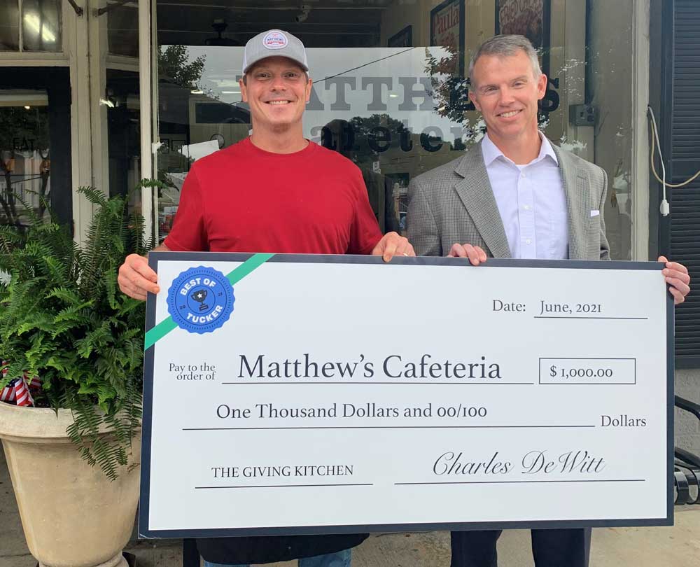 Matthew's Cafeteria owner accepts check for Best of Tucker. 