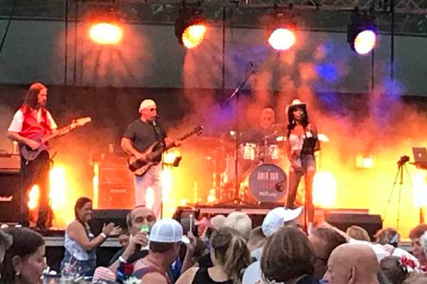 The American Flyers band performing on an outdoor stage.