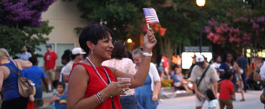 A Celebration of Independence attendee holds a small American flag.