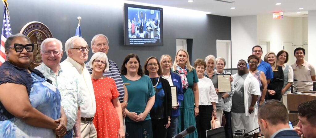 Representatives and volunteers of FODAC pose with the Tucker Mayor and Council along with patrons and staff of Peter & Paul's Place.