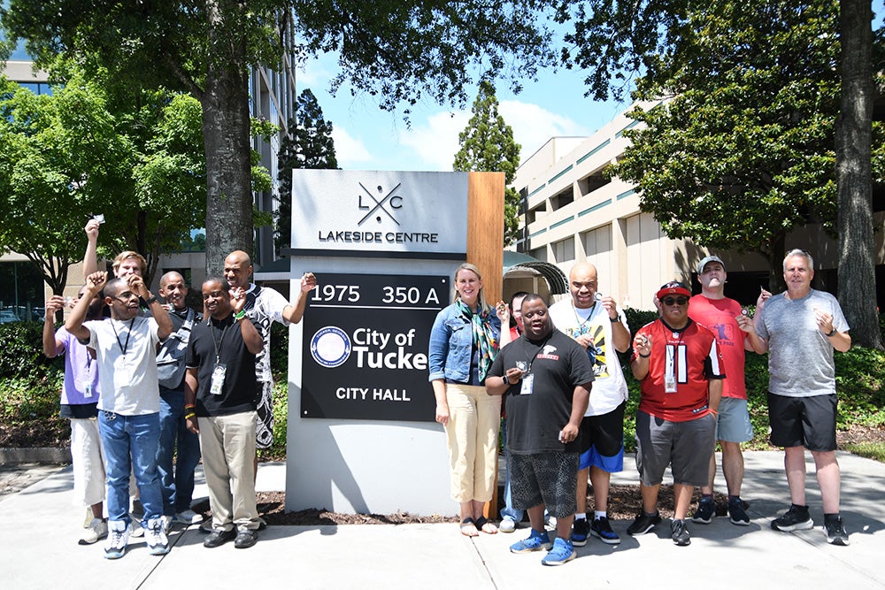 WOW In-Sync poses with Mayor Anne Lerner by the City Hall sign.
